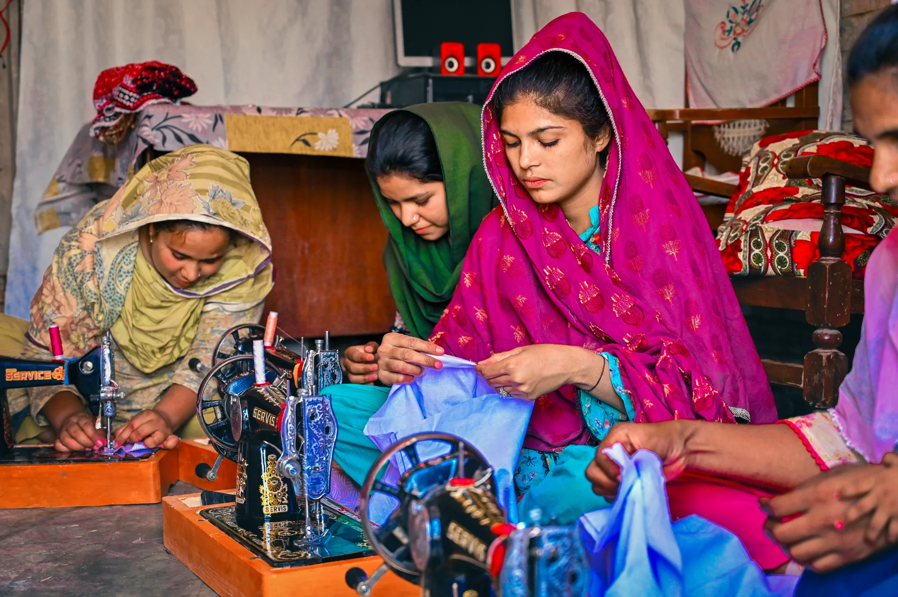 Women supporting one another as they work at sewing machines