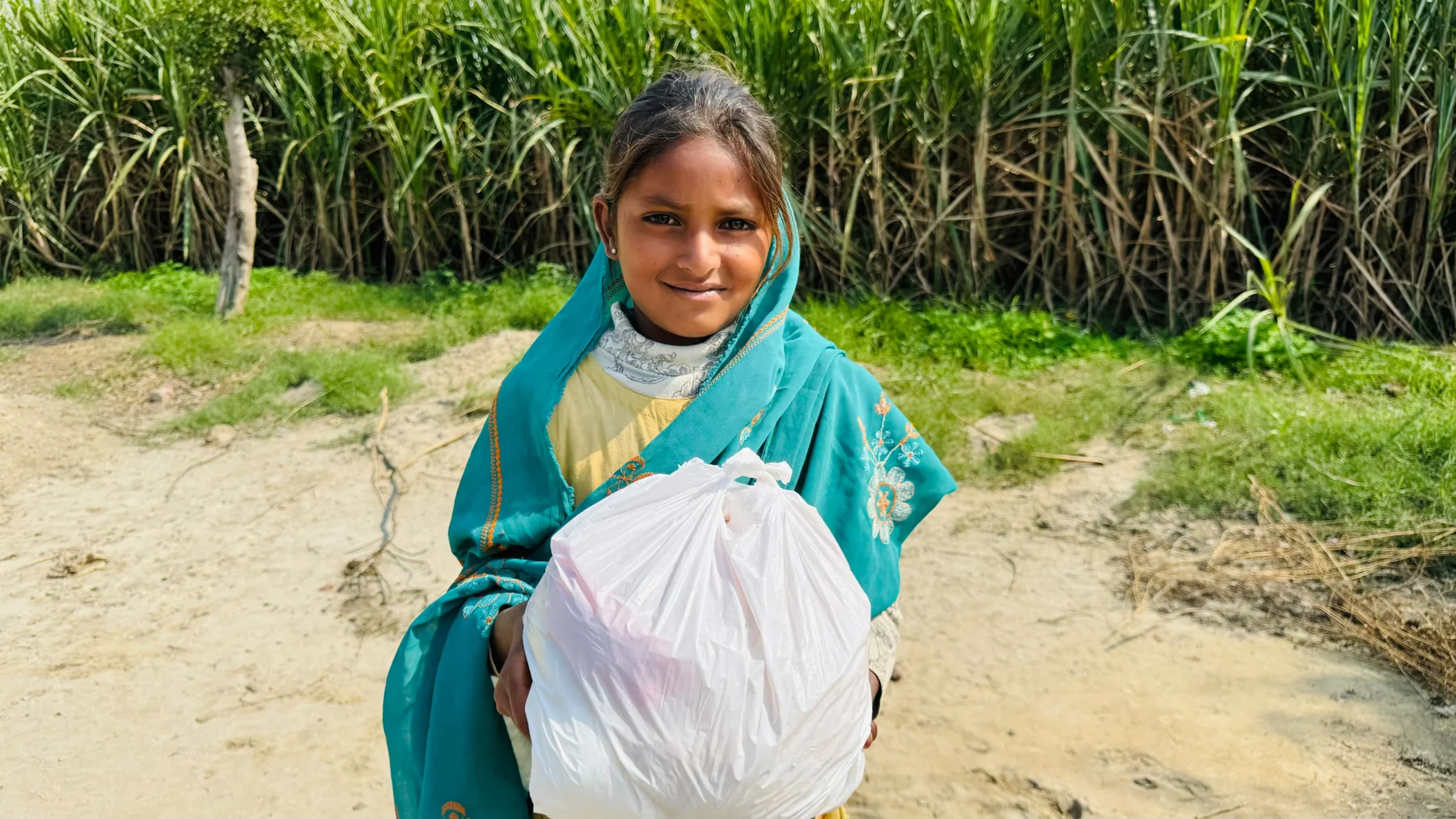A young person carrying a bag of food supplies
